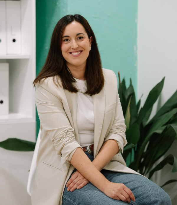 Ana, de EME Consultores, asesora de autónomos y empresas, sentada sobre una mesa