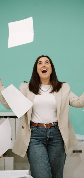Ana, de EME Consultores, lanzando un montón de papeles al aire