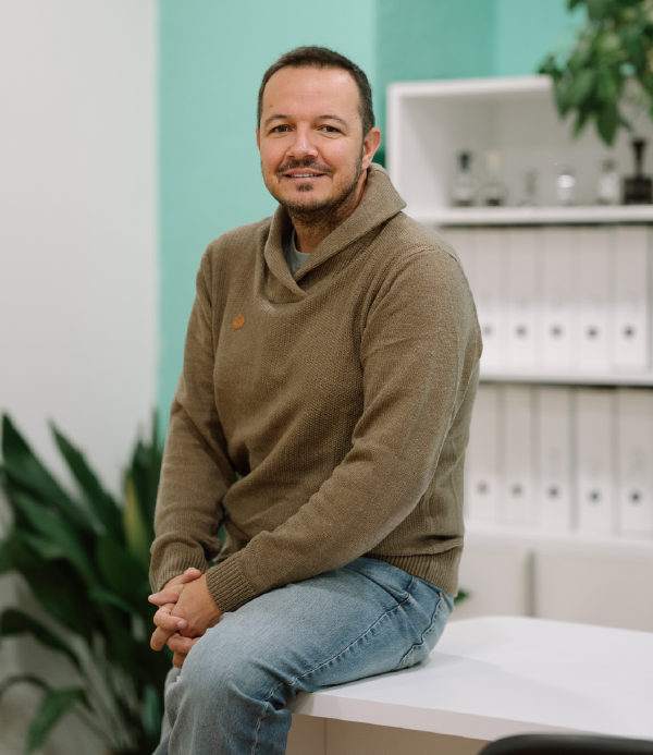 Víctor, de EME Consultores, gestoría de autónomos online y en Jaén, sentado sobre una mesa